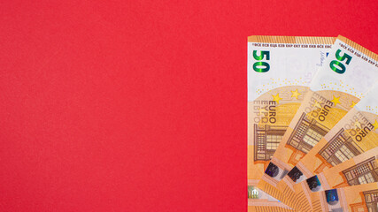 Fragment of the 50 fifty euro banknote on a red background. Close up currency money with place for text copy space.
