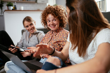 Girlfriends talking and laughing in office. Beautiful women drinking coffee in the office...