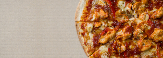 Closeup spicy new orleans chicken flavor pizza in brown paper tray box.