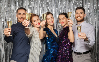 celebration and holidays concept - happy friends toasting champagne glasses at party