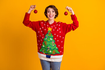 Photo of positive excited girl hold x-mas tradition christmas tree toys baubles wear theme party sweater jumper denim jeans isolated over bright shine color background