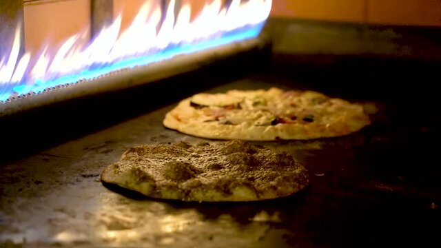 Arabic pizzas cooked inside a gas stove at a restaurant.