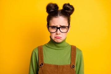 Photo of sad sorry lady two funny buns geek nerd student failed examination crying unhappy tears grimacing wear specs green pullover brown overall isolated yellow color background