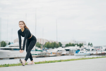 does forward leaning exercises aerobics healthy lifestyle. stylish tight comfortable clothing. portrait of a beautiful athletic brunette woman of Caucasian appearance.