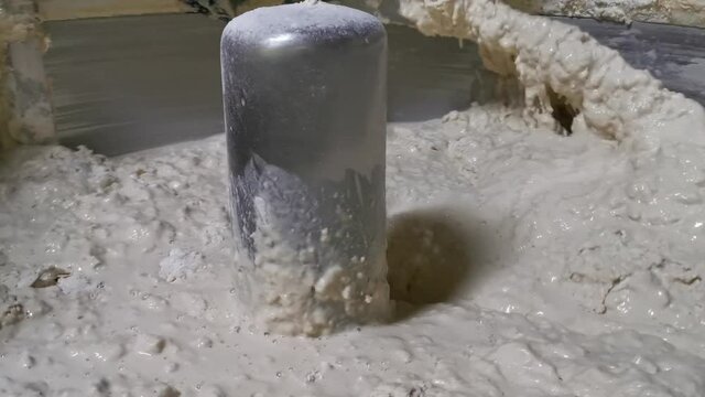 Close up for bread making process by using flour mixing machine in the factory. Stock footage. Preparation of dough with professional kneader machine at the manufacturing.