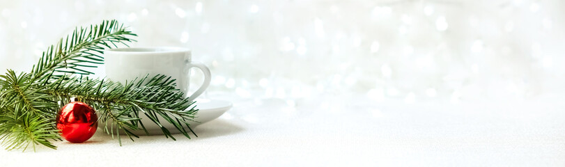 white coffee Cup on white background. Near branch of a spruce and ball. concept of Christmas. Long banner with copyspace