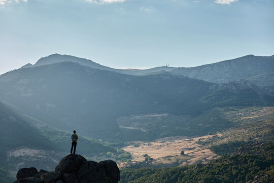 A mountaineer contemplates La Pedriza from the top of a rock in the Sierra de Guadarrama National Park. Madrid's community. Spain.