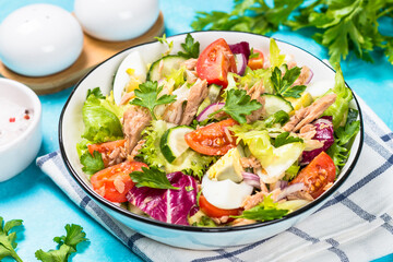 Tuna salad with green leaves, eggs and vegetables.