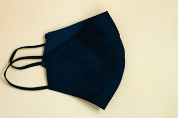 black medical face maskon beige background, close-up