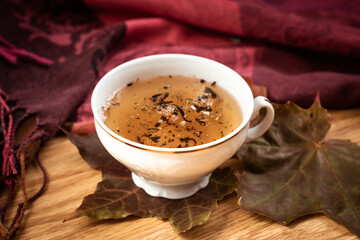 a white mug of tea and yellow leaves. the view from the top