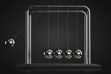 Newton's cradle in action. Dark background.