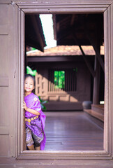 little asian girl in Thai period dress standing in ancient house