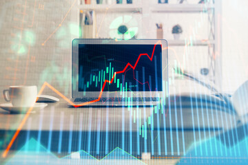 Financial chart drawing and table with computer on background. Double exposure. Concept of...