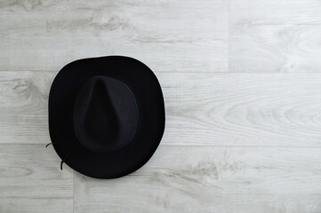 Black cowboy hat on gray wooden background. Place for text.
