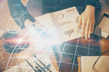 Multi exposure of hands making notes with world map hologram and data theme icons. Concept of global data.