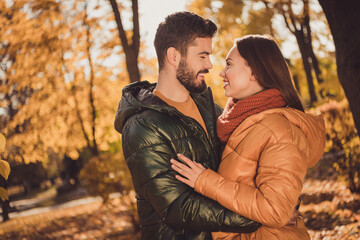 Photo of bonding couple guy embrace cuddle his girlfriend in outside autumn town park wear season coat