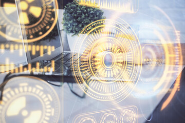 Technology theme hologram with man working on computer on background. High tech concept. Multi exposure.