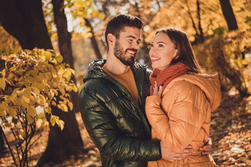 Fototapeta premium Photo of affectionate romantic couple guy hug his girlfriend in autumn september outside forest park