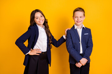 Portrait of his he her she attractive small little cheery schoolkids first date long-haired girl supporting embracing modest guy isolated over bright vivid shine vibrant yellow color background
