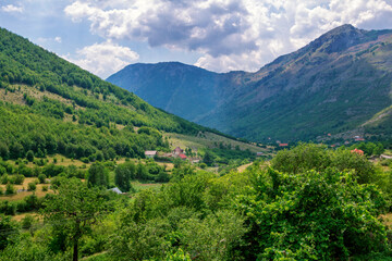 Summer landscape –Albanian mountains, covered with green trees, clouds on blue sky.