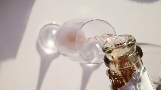 Close-up of rose sparkling wine pouring into the classic glass. Slow motion