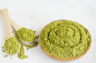 Moringa powder in wooden bowl with on white background. Healthy product, superfood, vitamin.Moringa Oleifera
