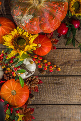 Festive autumn background, with traditional decor - pumpkins, berries, fruits, leaves on old wooden background. Thanksgiving day and Halloween holiday greeting card concept. Autumn flatlay
