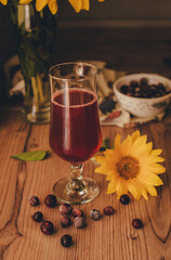 Still life. Frozen berries cherries cherry juice and sunflowers on wooden background