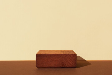 Horizontal template for mockup, banner. Wooden pedestal on brown beige background. Flat square stand or podium for natural design concept. Center composition, hard light, front view