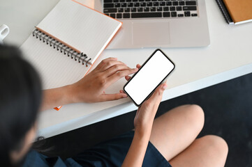 Top view woman holding a white screen smartphone on her office table.Template for your designs easy editable.
