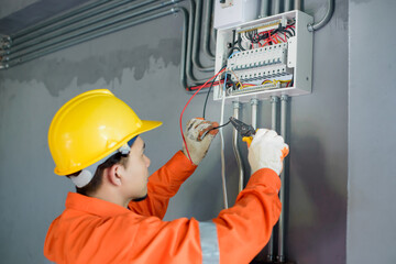 Asian male electricians inspect and install electrical systems in houses and buildings.