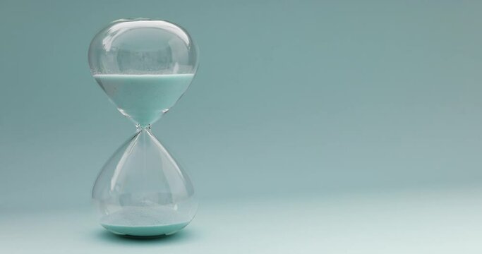 4k timelapse video of turquoise hourglass showing running time