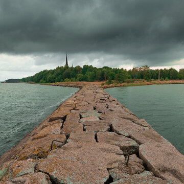 View of the coast of the city of Primorsk in the Leningrad region with the Kirkha spire from the Stone Pier. On a summer cloudy day