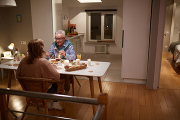 Fototapeta na wymiar Family of two talking to each other during dinner in the evening at home