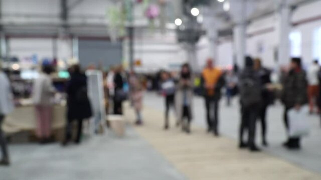 Defocused, blurred image of a crowd of people. Flea market, hangar fair, garage sale.