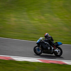 A panning shot of a racing bike as it circuits a track.