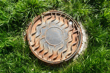 Metal manhole on the lawn