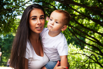Naklejka premium young pretty brunette mother with little cute boy walking in park happy smiling, lifestyle people concept