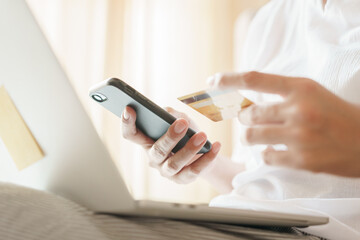 Close up hand of women are buying online with a credit card. woman are using smartphone and doing online transactions.