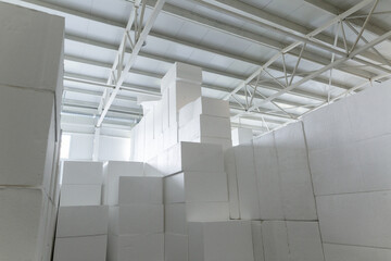 Obraz premium Industrial production of polystyrene foam insulation panels or plates from expanded polystyrene. A large blocks of Styrofoam are stacked in a warehouse. Building materials.