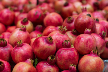 Juicy and tasty pomegranate fruit background. Pile of fresh ripe pomegranates.
