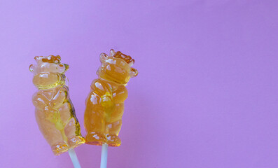 two lollipops in the form of a bull, curly candy, on a pink background with a place for text,...