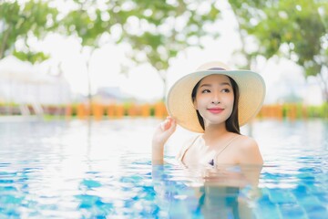 Portrait beautiful young asian woman relax smile around outdoor swimming pool in hotel resort