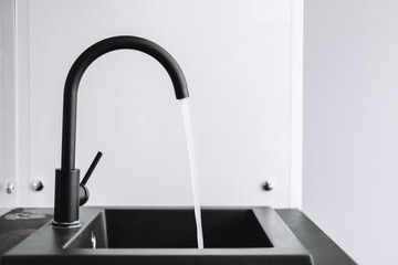 A running tap with the water running in the kitchen. The tap lets the water run, nobody.