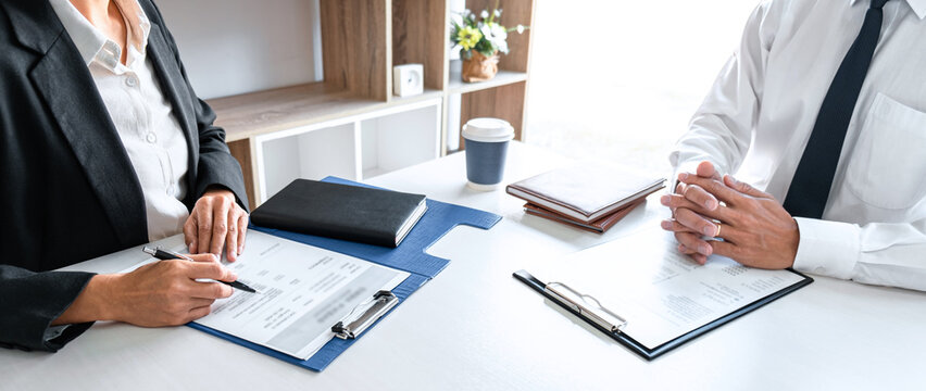 The manager reading a resume during a job interview, Employer interviewing to ask young male job seeker for recruitment talking in office