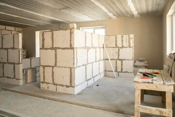 Interior of unfinished gas blocks apartment with concrete floor under construction.