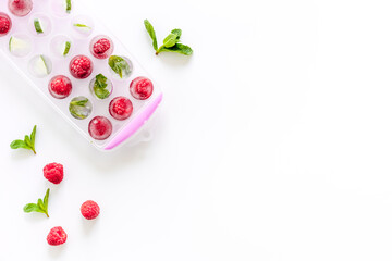 Ice tray with berries, lime and mint on white background top view copy space