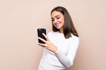 Naklejka premium Young woman over isolated background taking a selfie with the mobile