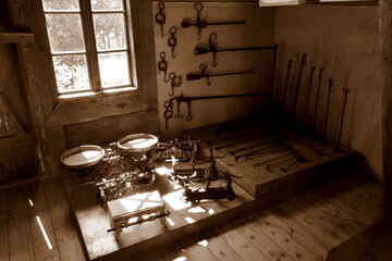 View of an interior of an old historic mill with all the important equipment like scales, poles, and sticks located in the corner of the main room seen on a Polish countryside during a sunny day