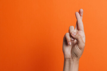 Close up of woman's fingers showing crossed fingers - obrazy, fototapety, plakaty